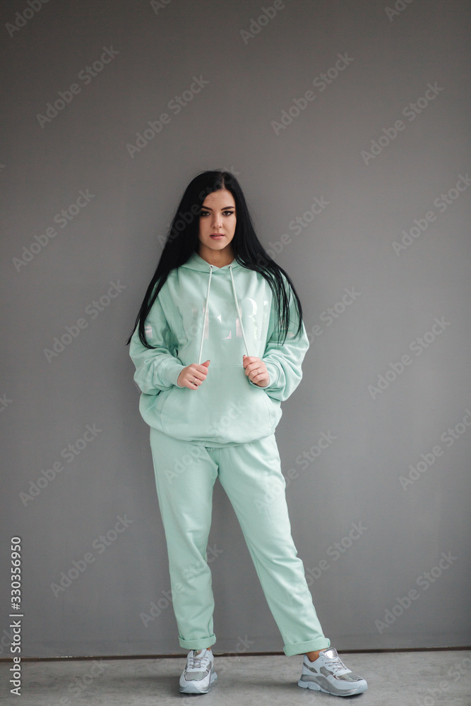 Attractive young model in tracksuit. Woman demonstrating clothes in