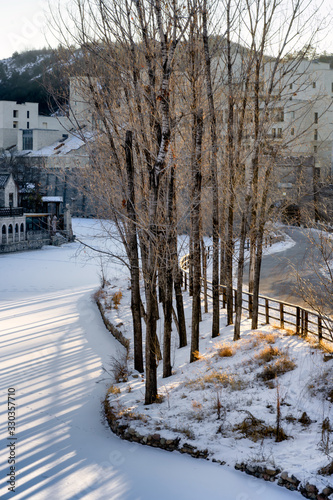 Morning sun shining through the trees snow covered the river at Gubei water town in Beijing,China. photo