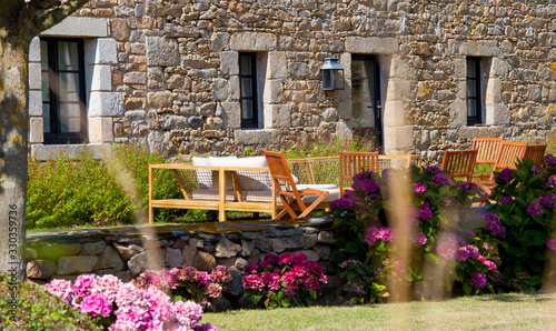 Jardine paysagé en Bretagne et maison de pierre en granit. photo