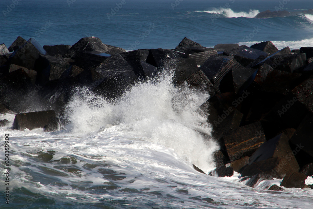 Wave hitting the rocks in the shore in San Sebastian