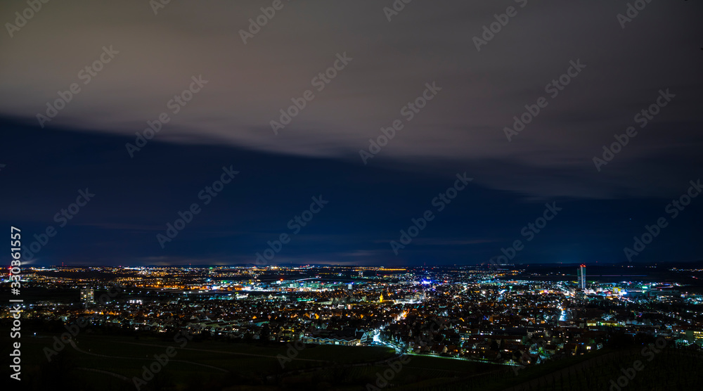 Germany, Panorama aerial view above houses, skyline, tower and streets of fellbach city near stuttgart, illuminated lights by night