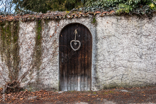 Old wooden door in a long stone wall photo