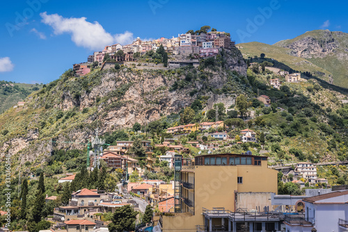 Castelmola town on a rocky hill, view from stairs of Way of Cross in Taormina city on Sicily Island, Italy photo