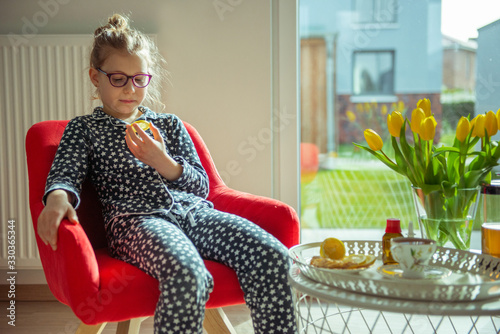 Portrait of little sick child in mask with lemon and at quarantine becouse of coronavirus photo