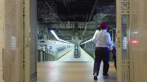 Man with turban and umbrella walks down empty platform track Grand Central Station