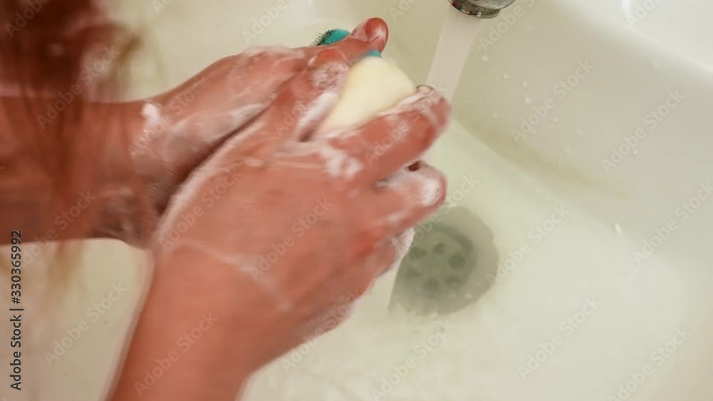 Close up of girl's hands in foam. Girl washes hands thoroughly with soap and sponge Close up of girl's hands in foam. Girl washes hands thoroughly with soap and sponge
