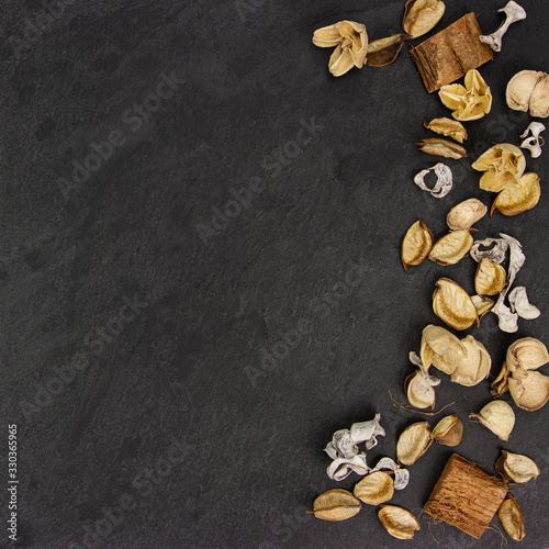 Dried aroma flowers on the dark textured background. Aromatic Flower fragrance on black background.