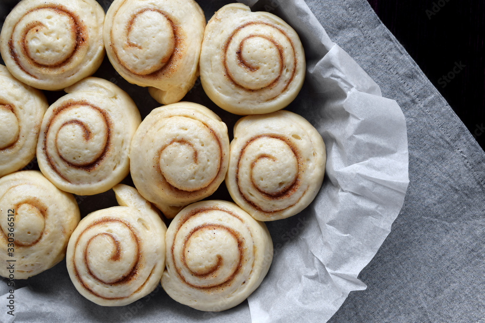 Fototapeta premium Raw cinnamon rolls of yeast dough ready to be baked