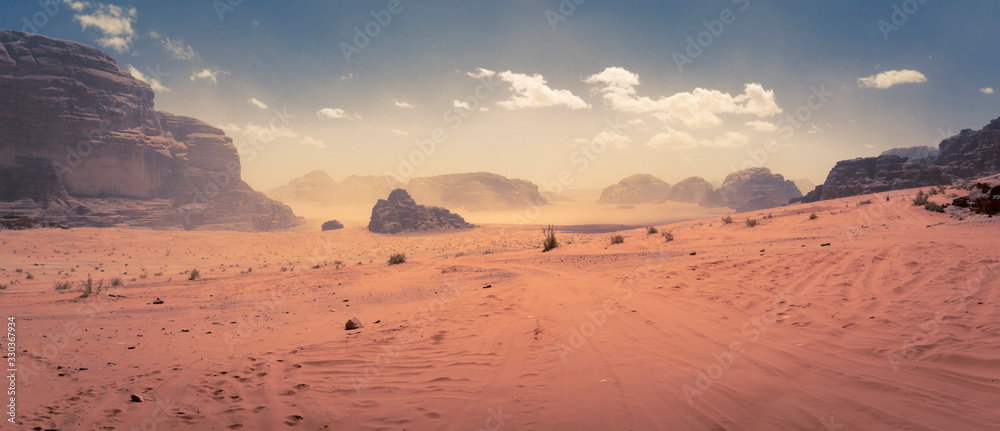 Panorama of the Wadi Rum desert in Jordan during a slight sand storm - obrazy, fototapety, plakaty 