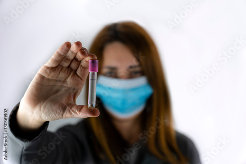 Unfocused young girl with a medical mask putting a pharmaceutical Aprotinin medical tube. photo