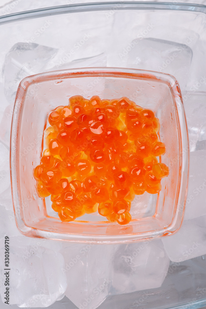 fresh red salmon caviar in glass bowl. served around ice. macro shot. Protein luxury delicacy healthy food. flat lay fresh red salmon caviar in glass bowl. served around ice. macro shot. Protein luxury delicacy healthy food. flat lay