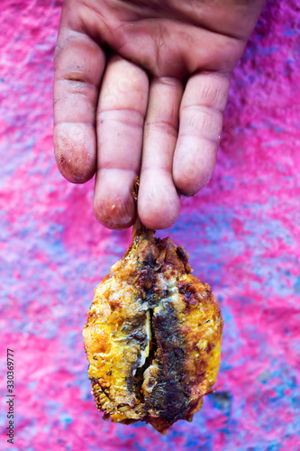 Man hand holding spicy, Moroccan fried sardines with chermoula photo