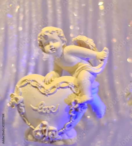 Fototapeta Naklejka Na Ścianę i Meble -  Angel statues on wedding table with love written word on hearts