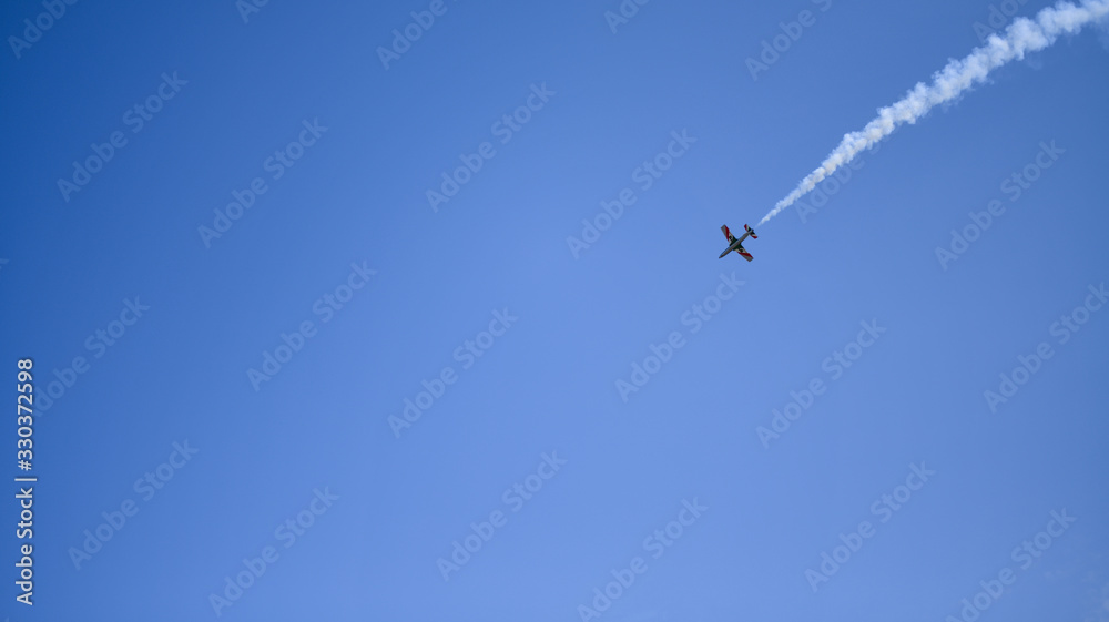 the plane against the blue sky flies from the upper right corner the plane against the blue sky flies from the upper right corner