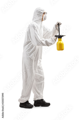 Man in a hazmat suit spraing with a disinfectant photo