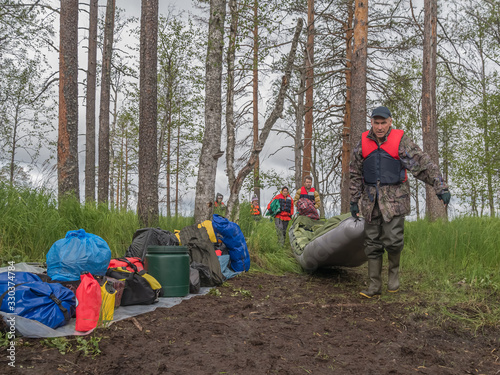 Active extreme holidays in Karelia. Men transfering boat. Water tourism photo