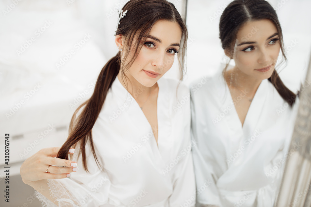 Elegant bride near the mirror at the morning Elegant bride near the mirror at the morning