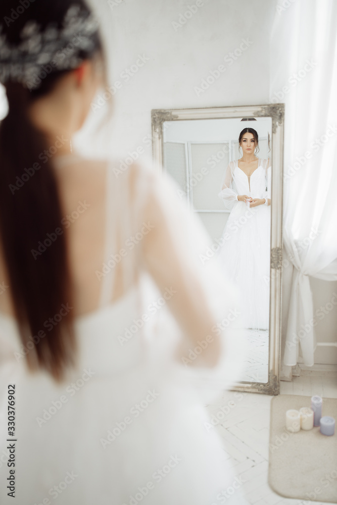 Elegant bride near the mirror at the morning Elegant bride near the mirror at the morning