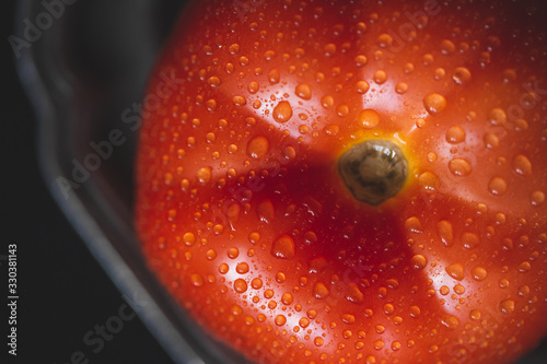 Fresh red organic tomato with water drops