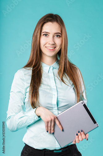 She always connected. Woman using digital tablet computer happy isolated on turquoise background. Portrait young caucasian woman worker, teacher, mentoring in shirt office style with tablet in hand