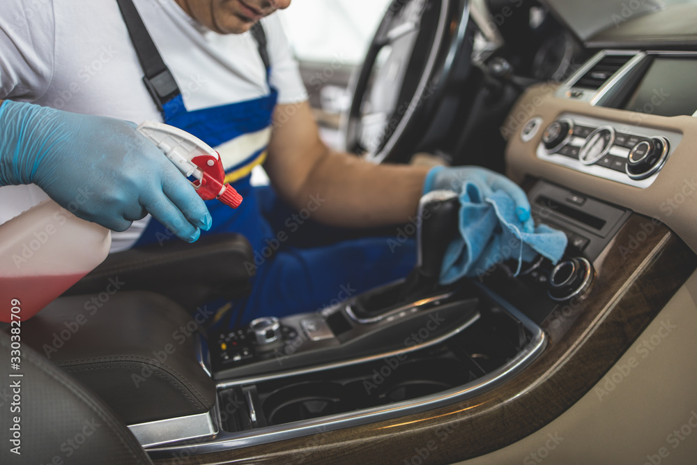 Man cleaning upholstery and interriour of his vehicle