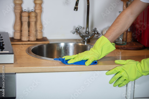 chores in kitchen, cleaning of water tap and sink with gloves