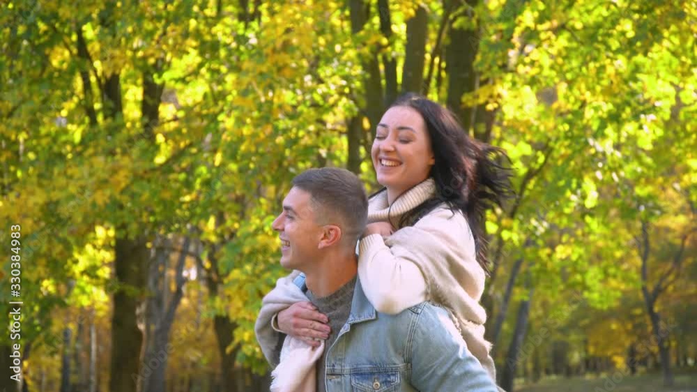Laughing joyful family. Happy couple having fun in the autumn park Laughing joyful family. Happy couple having fun in the autumn park