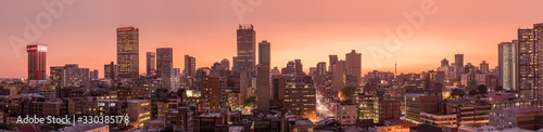 A beautiful and dramatic panoramic photograph of the Johannesburg city skyline  taken on a golden evening after sunset.