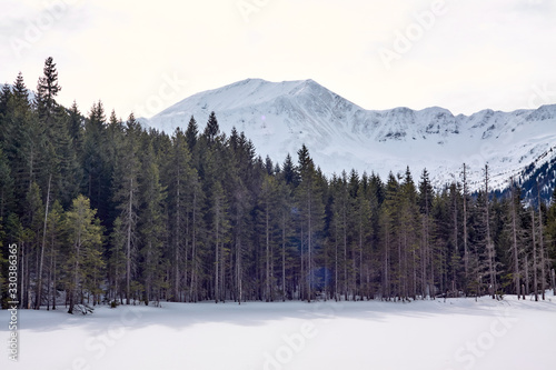 Winter panorama of West Tatra mountain range from frozen and snow-covered Smreczynski Lake (Smreczyński Staw), Poland