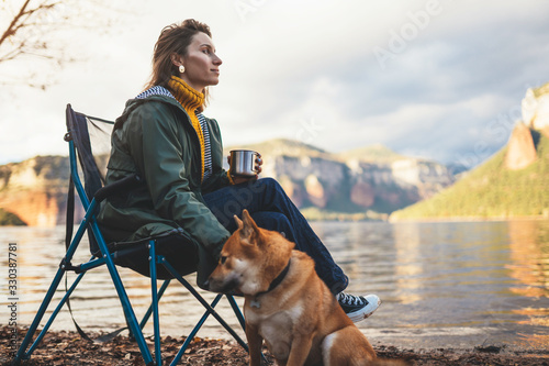 tourist traveler drink tea girl relax together dog on background mountain landscape,  woman hug pet rest on lake shore vacation © A_B_C