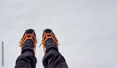 Tourist wearing crampons for winter hiking in the mountains