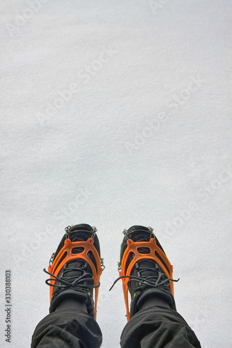 Tourist wearing crampons for winter hiking in the mountains