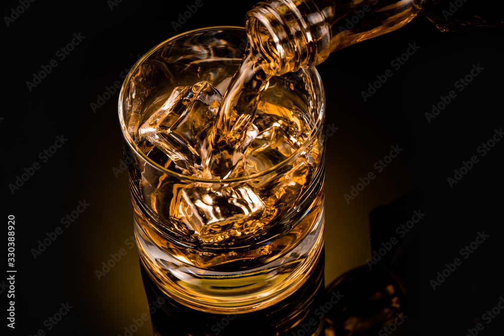glass of whiskey on black background	