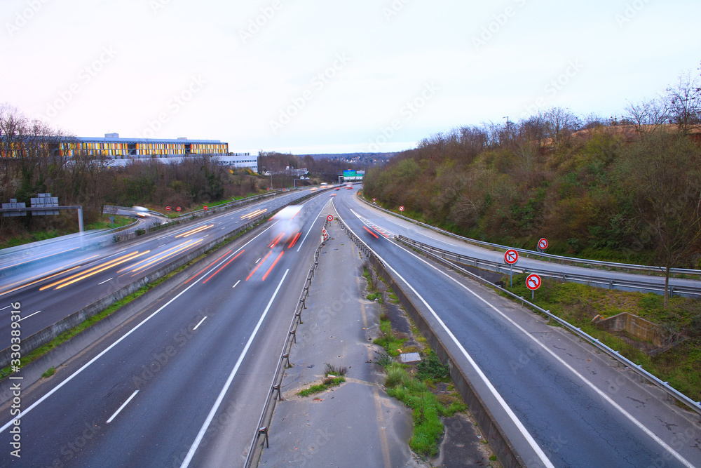 Moving cars and trucks driving on a fast lane. Vehicles on the highway. Transport photographed in long exposure mode in lightpainting. Moving cars and trucks driving on a fast lane. Vehicles on the highway. Transport photographed in long exposure mode in lightpainting.