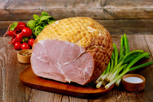 Obraz na plátně Delicious cooked ham on a wooden board with green onion and radish