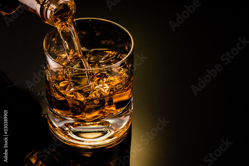 Fototapete glass of whiskey on black background