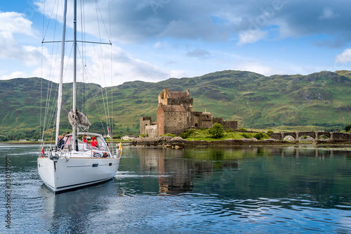 Sailing yacht crew taking photos of Eilian Donan Castle. Inner Hebrides cruise, Scotland. photo