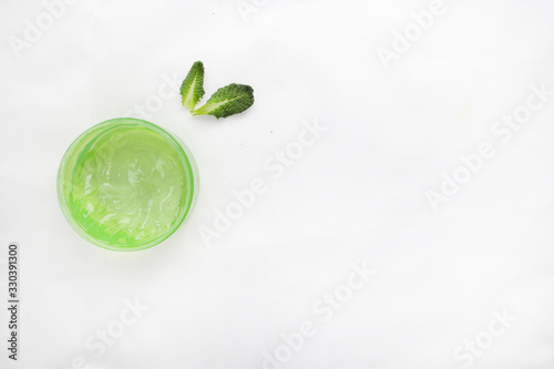 Jar of cream and flowers on white background, top view. Professional cosmetic products