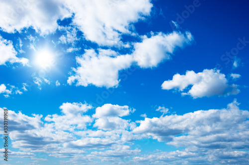 Blue sky with clouds and sun.