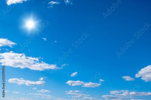 Blue sky with clouds and sun.