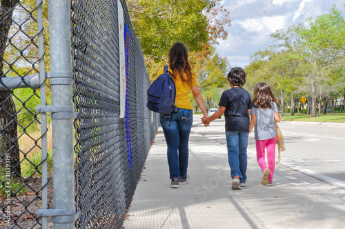 coronavirus kids school empty mom kids walk closeup fence exterior walk cough elbow abandoned trapped scary book walk in hold notebook empty young boy girl waiting ride home pickup covid19