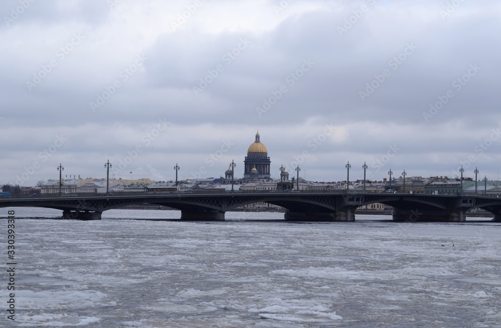St. Petersburg. View of the winter Neva river on a cloudy day. In the distance you can see the bridge and St. Isaac's Cathedral St. Petersburg. View of the winter Neva river on a cloudy day. In the distance you can see the bridge and St. Isaac's Cathedral