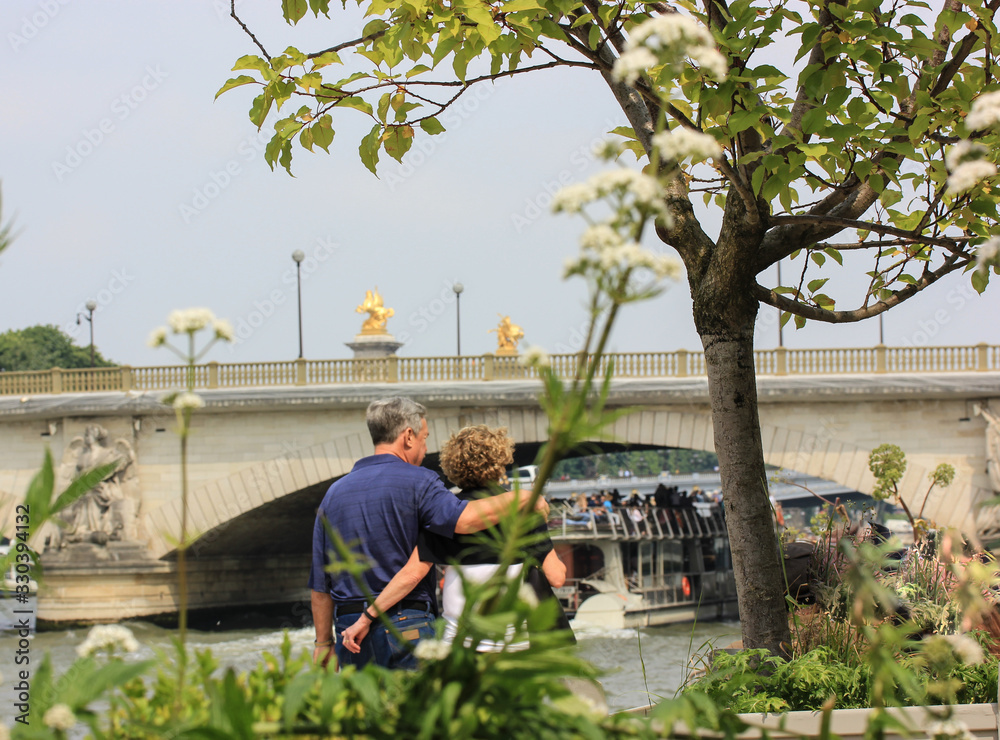 Lovers walk along the waterfront near the Seine River in Paris, France. Lovers walk along the waterfront near the Seine River in Paris, France.