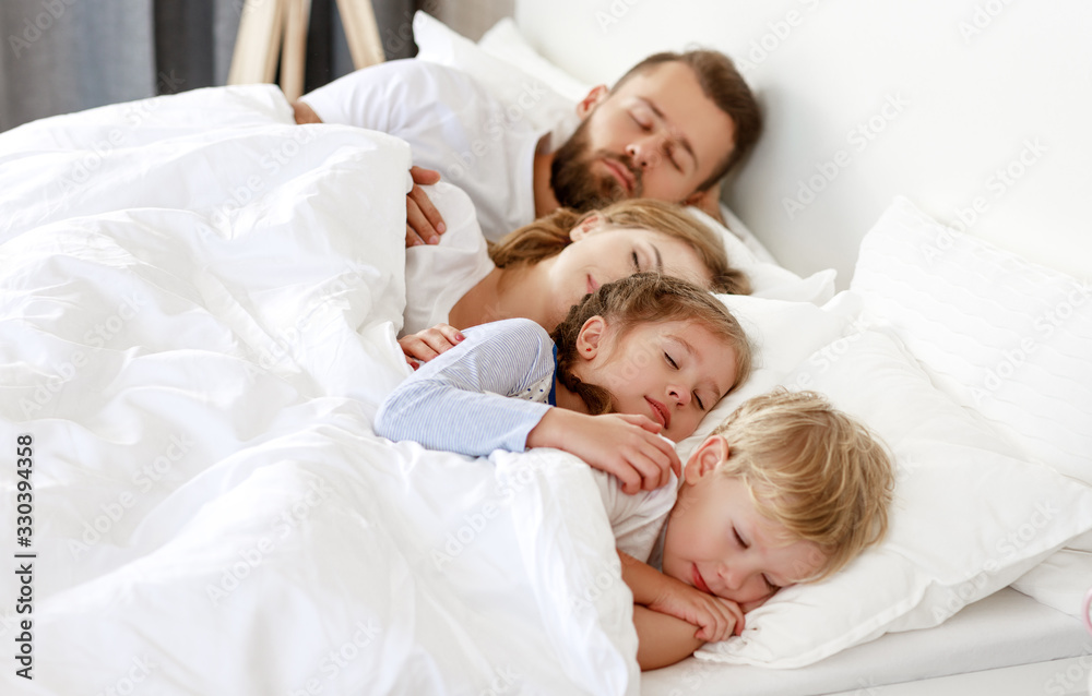 healthy sleep. happy family parents and children sleeping in white bed . healthy sleep. happy family parents and children sleeping in white bed .