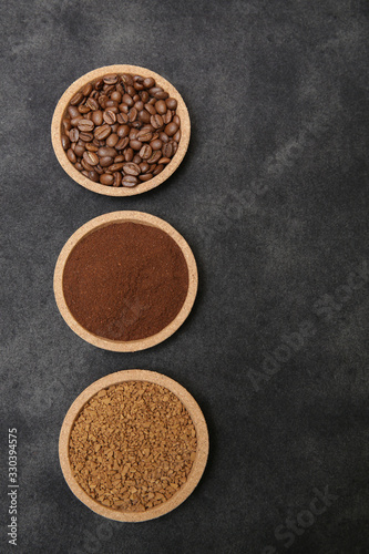 Coffee various - roasted beans or grain and ground and instant coffee on black fabric background. The sequence of preparation of the drink. Coffee concept. Flat lay. Top view. Copy space for text. 