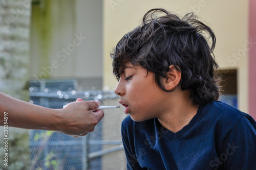 coronavirus school thermometer closeup young boy hand out testing sanitize thermometer young boy hand out mom testing sick