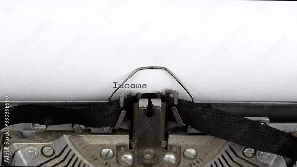 Typing a text income tax 2020 close-up view. Old vintage typewriter with a white empty sheet of paper. Concept of finance, paperwork and bookkeeping