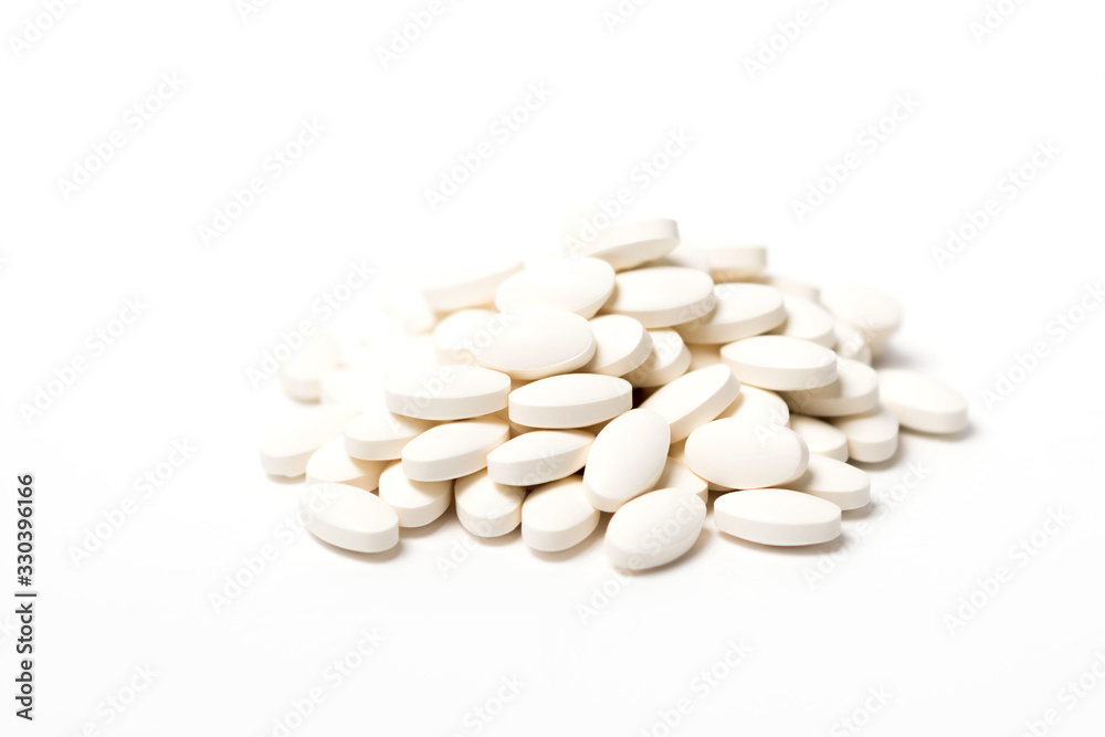 A pile of white oval-shaped tablets on a white background.