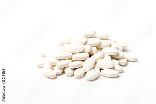 A pile of white oval-shaped tablets on a white background.
