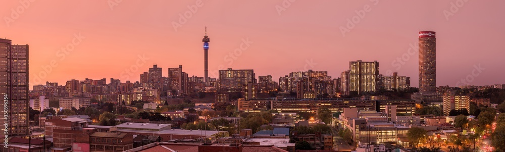 Naklejka premium Piękne i dramatyczne zdjęcie panoramiczne panoramy miasta Johannesburg, wykonane w złoty wieczór po zachodzie słońca.